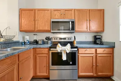 a kitchen with wooden cabinets and a stove top oven at 8460 CRYSTAL COVE LOOP 3BED in Kissimmee