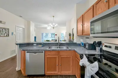 a kitchen with a sink and a stove top oven at 8460 CRYSTAL COVE LOOP 3BED in Kissimmee