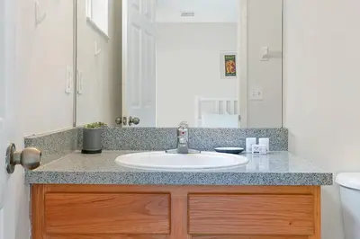 a bathroom counter with a sink and a mirror at 8460 CRYSTAL COVE LOOP 3BED in Kissimmee