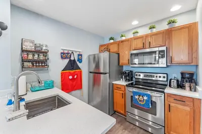 a kitchen with stainless steel appliances and wooden cabinets at 4005 SAN SABASTIAN DRIVE 3BED in Kissimmee