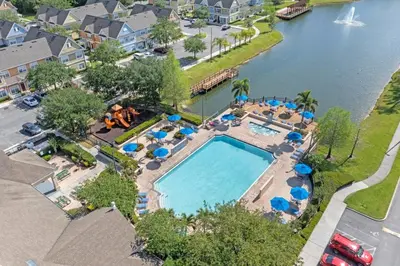 an overhead view of a swimming pool with blue umbrellas at 4005 SAN SABASTIAN DRIVE 3BED in Kissimmee
