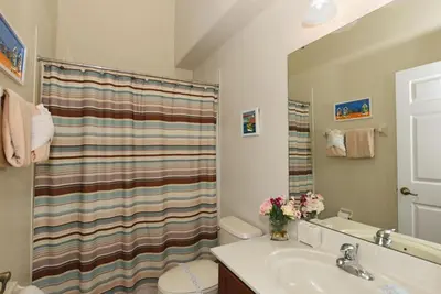 a bathroom with a shower curtain and a sink at Veranda Palms Villa: Pool, Spa & Game Room in Kissimmee