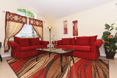 a living room with two red couches and a table at Veranda Palms Villa: Pool, Spa & Game Room in Kissimmee
