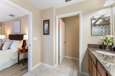 a bathroom with a sink and a bed in a room at 4BR Retreat with Resort Access and Pool in Kissimmee