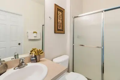 a bathroom with a toilet and a sink and a shower at Windsor Hills Getaway: 3BR, Pool, Near Disney in Orlando