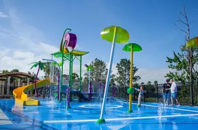 a water park with people playing in the water fountain at Windsor Hills Getaway: 3BR, Pool, Near Disney in Orlando