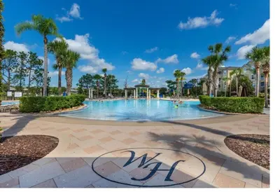 a swimming pool at a resort with palm trees at Windsor Hills Getaway: 3BR, Pool, Near Disney in Orlando
