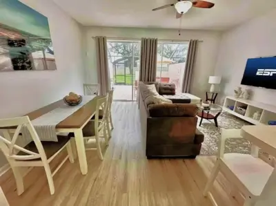 a living room with a couch and a dining table at Your Cozy 3 BD Home w Private Hot Tub & BBQ Gril in Kissimmee