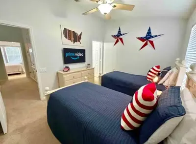 two beds in a bedroom with stars on the wall at Your Cozy 3 BD Home w Private Hot Tub & BBQ Gril in Kissimmee