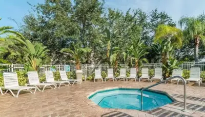 a swimming pool with chaise lounge chairs and a swimming pool at Your Cozy 3 BD Home w Private Hot Tub & BBQ Gril in Kissimmee