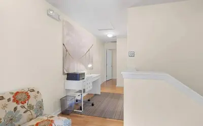 a white living room with a chair and a desk at Cozy Home with 3BD & BBQ Grill in Orlando
