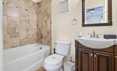 a bathroom with a toilet and a sink and a bath tub at Cozy Home with 3BD & BBQ Grill in Orlando