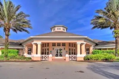 a large building with palm trees in front of it at Windsor Palms Condo | Pool, Spa & Near Disney in Kissimmee