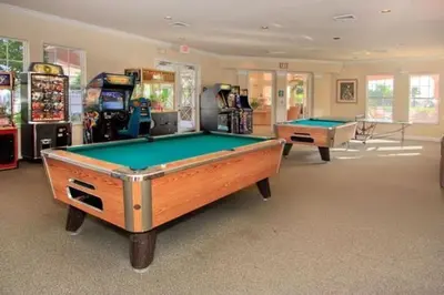 a room with two pool tables and arcade machines at Windsor Palms Condo | Pool, Spa & Near Disney in Kissimmee