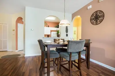 a kitchen and dining room with a table and chairs at Windsor Palms Condo | Pool, Spa & Near Disney in Kissimmee