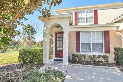 a house with a red door and a driveway at Windsor Palms Escape w/ Splash Pool in Kissimmee