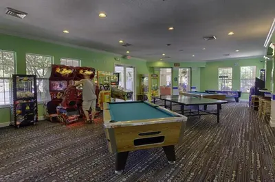 a man playing a game in a gaming room with pool tables at Windsor Palms Escape w/ Splash Pool in Kissimmee