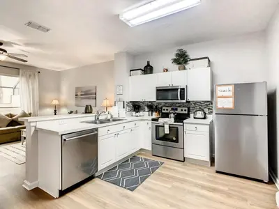 a kitchen with white cabinets and stainless steel appliances at Windsor Palms Townhome w/Private Pool Near Disney in Kissimmee