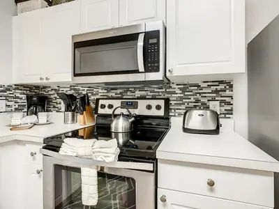 a kitchen with a stove and a microwave at Windsor Palms Townhome w/Private Pool Near Disney in Kissimmee