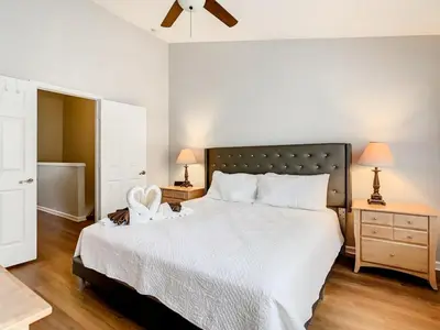 a bedroom with a large bed with a white bedspread at Windsor Palms Townhome w/Private Pool Near Disney in Kissimmee