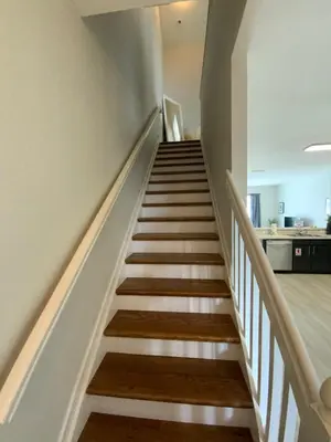 a staircase in a house with white walls and wooden floors at Townhome in Orlando