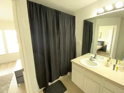 a bathroom with a sink and a black shower curtain at Townhome in Orlando
