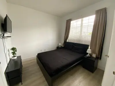 a bedroom with a black bed and a window at Townhome in Orlando