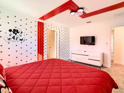 a bedroom with a red bed and a tv at Lovely Themed Room with Private Pool in Kissimmee