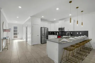 a kitchen with white cabinets and a large island with a sink at Storey Lake, 24 hóspedes, 9Q, piscina e vista lago in Kissimmee