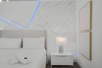 a bedroom with a white bed and a table with a lamp at Storey Lake, 24 hóspedes, 9Q, piscina e vista lago in Kissimmee