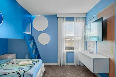 a blue bedroom with a bed and a desk at Storey Lake, 24 hóspedes, 9Q, piscina e vista lago in Kissimmee