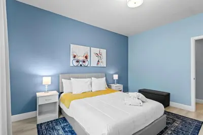 a bedroom with a large bed with blue walls at 12 min da Disney • Casa 3 Q c/ Resort in Kissimmee