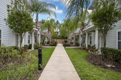 a walkway in front of houses with palm trees at 12 min da Disney • Casa 3 Q c/ Resort in Kissimmee