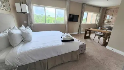 a hotel room with a large bed and a desk at 3053 Magic Village - Jacuzzi excepcional, a 8 minutos da Disney in Orlando