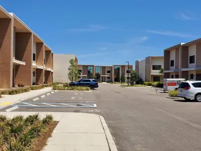 an empty parking lot with cars parked in front of buildings at 3053 Magic Village - Jacuzzi excepcional, a 8 minutos da Disney in Orlando