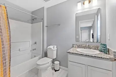 a white bathroom with a toilet and a sink at Compass Bay: 4Q reformados Perto da Disney! in Kissimmee
