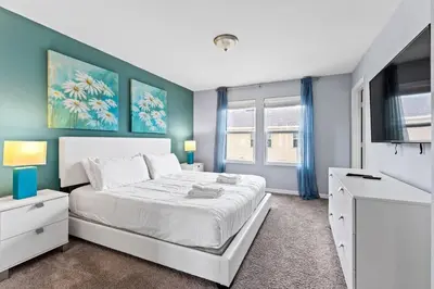 a bedroom with a white bed and a blue wall at Compass Bay: 4Q reformados Perto da Disney! in Kissimmee