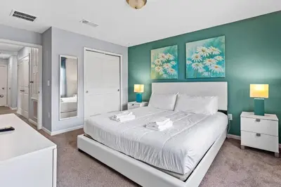 a bedroom with a large white bed and green walls at Compass Bay: 4Q reformados Perto da Disney! in Kissimmee