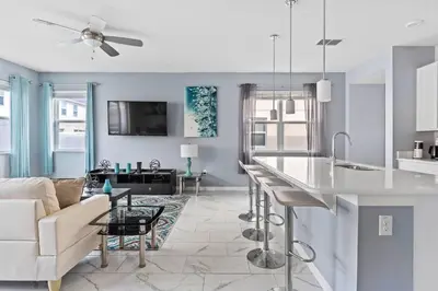 a kitchen and living room with a couch and a table at Compass Bay: 4Q reformados Perto da Disney! in Kissimmee