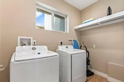 a laundry room with a white washer and dryer at Casa 3 Suítes c/ Churrasco – Perto da Disney in Orlando
