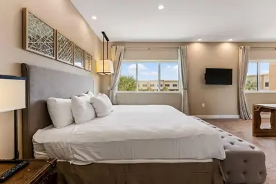 a bedroom with a large bed with white pillows at Casa 3 Suítes c/ Churrasco – Perto da Disney in Orlando