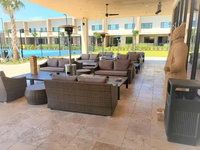 a patio with couches and tables and a building at Casa 3 Suítes c/ Churrasco – Perto da Disney in Orlando