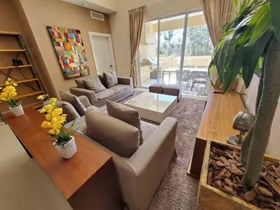 a living room with a couch and a table at Magic Village Casa com 4 Suítes - 8 min da Disney! in Orlando