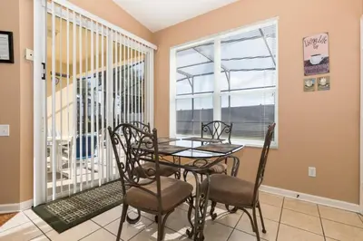 a dining room with a table and chairs and a window at Windsor Palms Villa: Pool & Close to Disney in Kissimmee