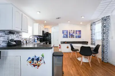 a kitchen with white cabinets and a table and chairs at New! Family cottage near Disney-Sleep 6 in Kissimmee