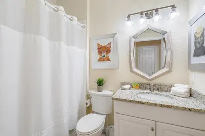 a bathroom with a toilet and a sink and a mirror at 7774 Basnett Circle in Kissimmee