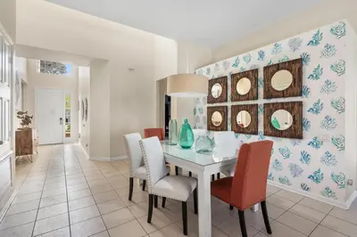 a dining room with a table with chairs and mirrors at 7774 Basnett Circle in Kissimmee