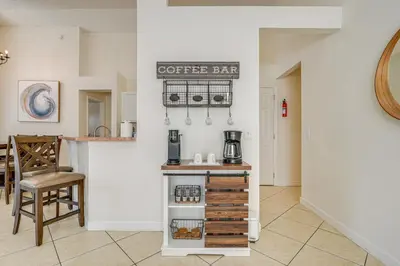 a coffee bar in a kitchen with a table at 9 Mi to Disney Home with Pool Table and Water Views! in Kissimmee