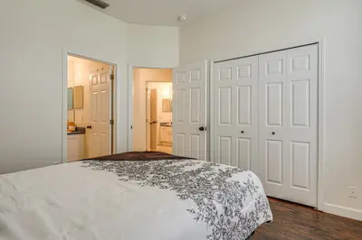 a bedroom with a bed and two white doors at 9 Mi to Disney Home with Pool Table and Water Views! in Kissimmee