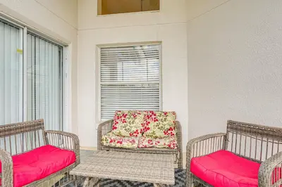 a porch with two wicker chairs with red cushions at 9 Mi to Disney Home with Pool Table and Water Views! in Kissimmee